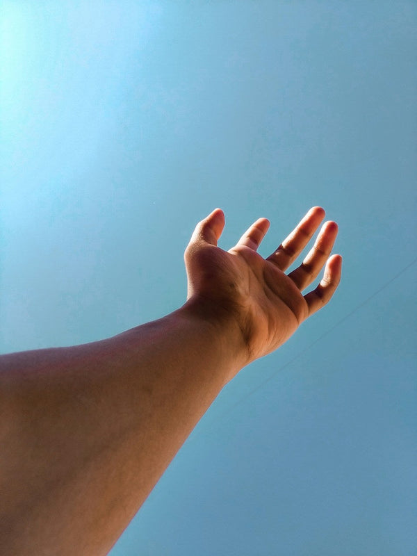 An open hand reaching toward the sky — symbolizing release, energy flow, and connection